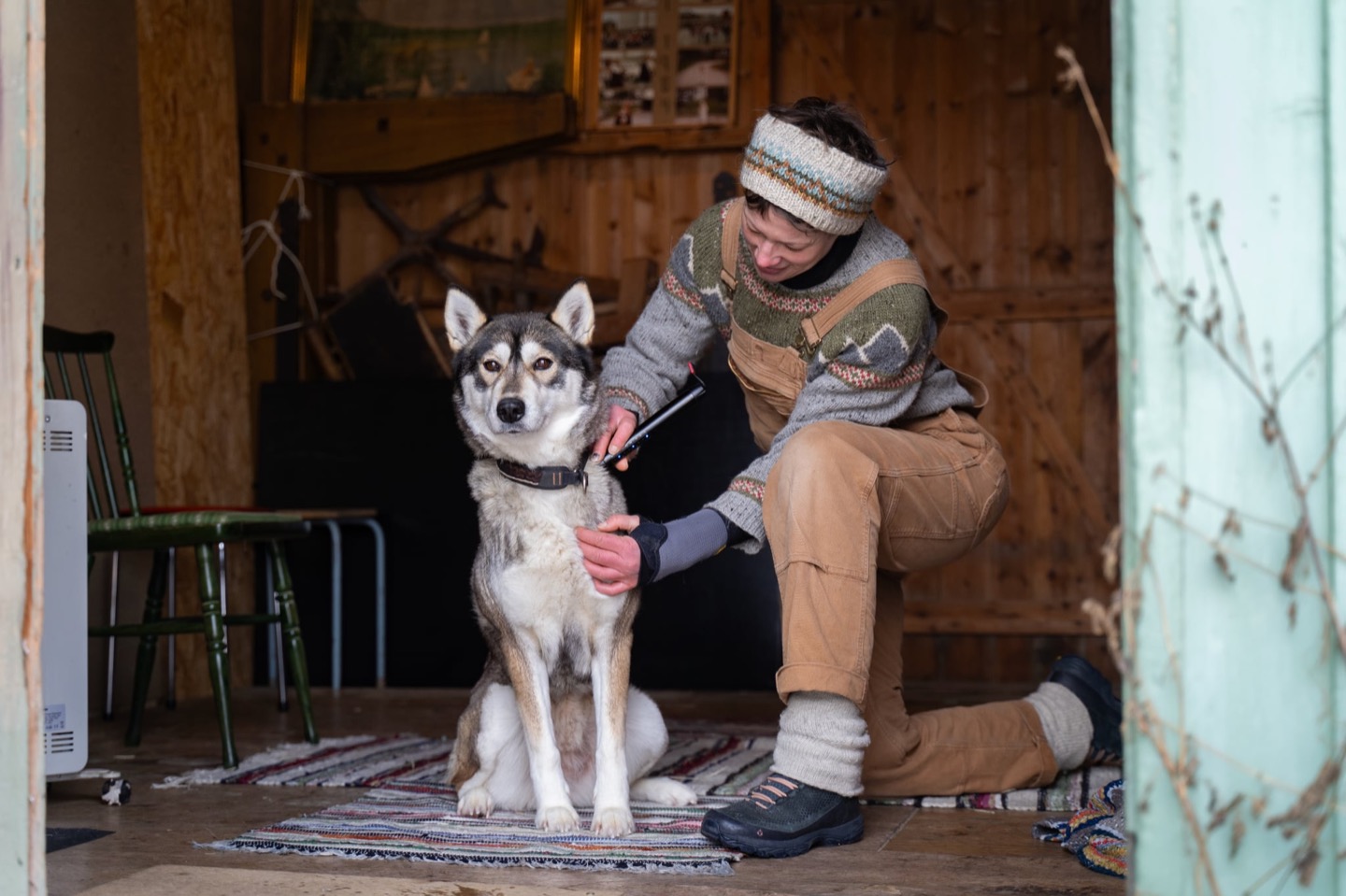 Annelin Brill med hendene på hodet og nakken til en husky